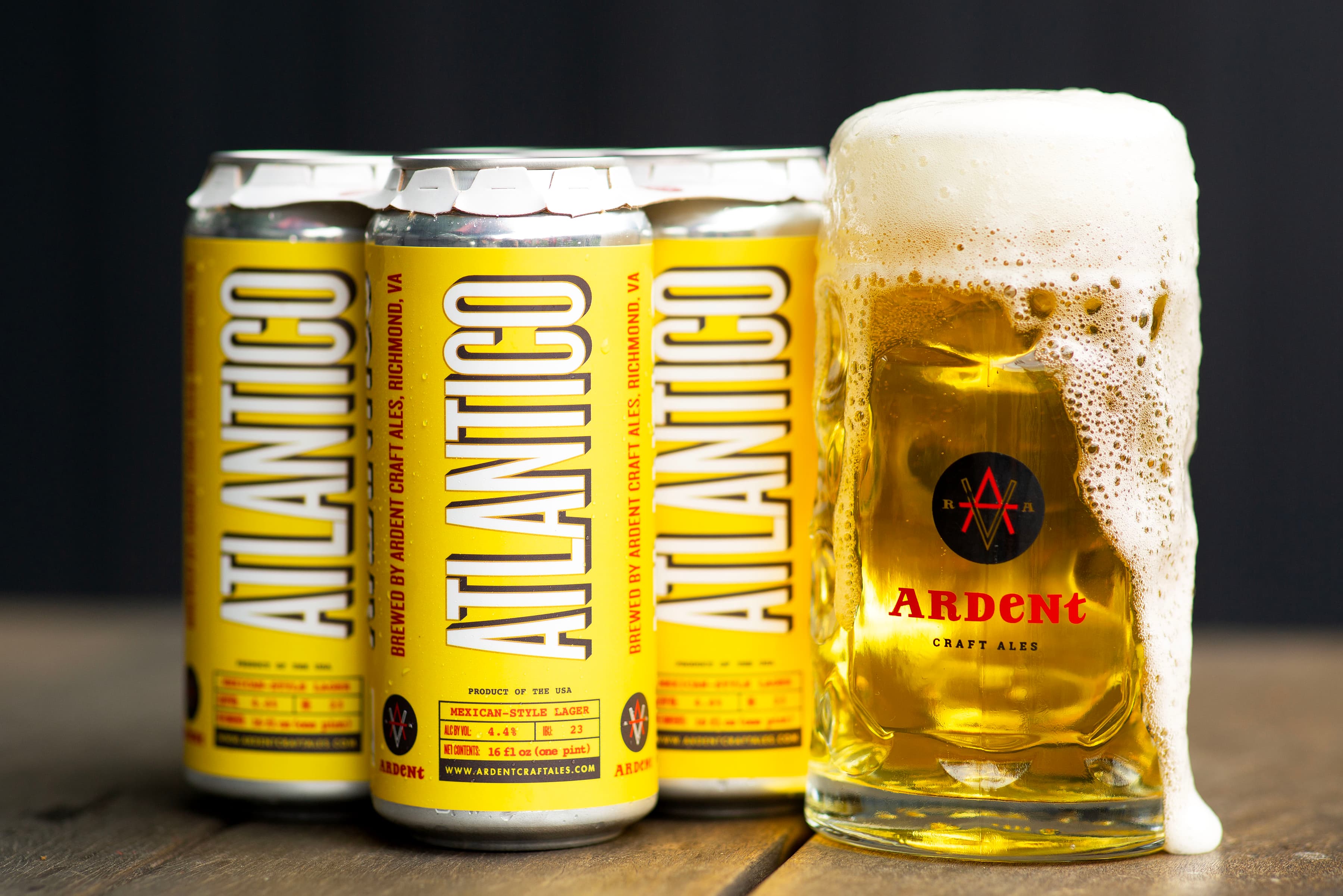 4-pack of dark blue 16oz cans of Bohemian Pilsner next to stein full of clear golden lager