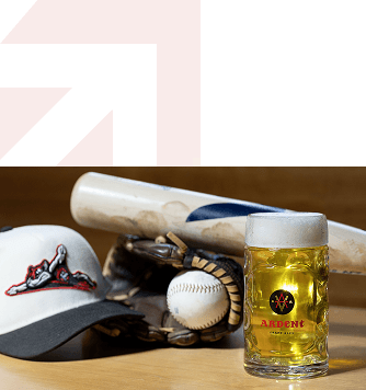 Stein of beer, baseball in baseball glove, baseball cap and baseball bat arranged on tabletop