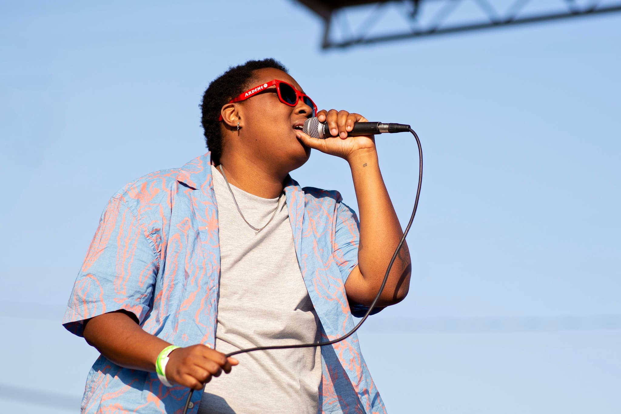 Singer wearing red Ardent sunglasses sing
